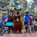 Family enjoying bikes and activities with Yogi Bear and Cindy Bear at Asheboro Jellystone Park in North Carolina