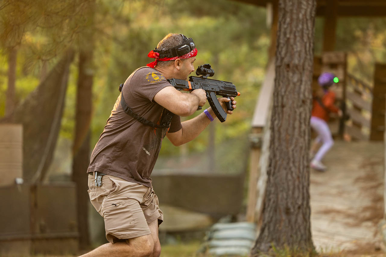 Guest enjoying outdoor laser tag in the wooded arena at Jellystone Park Asheboro