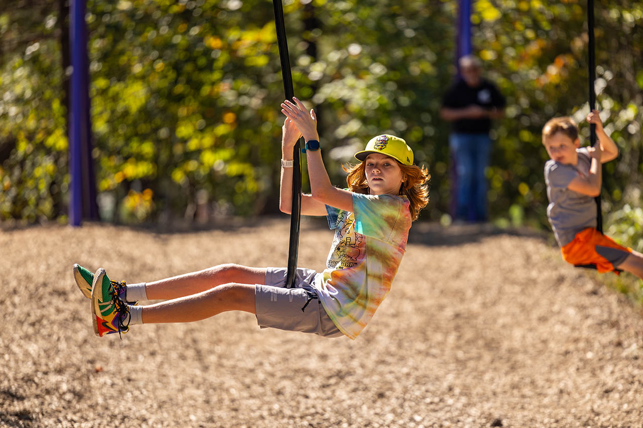 Children enjoying The Zipper low-riding zipline attraction at Jellystone Park Asheboro